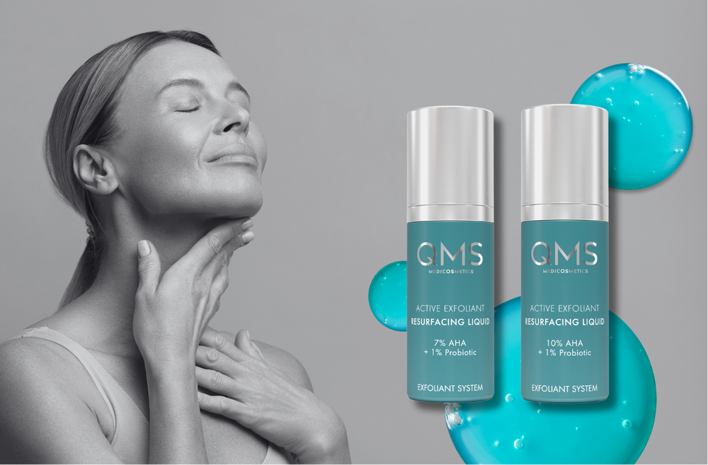 Woman touching her neck with two bottles of GMS skincare product on a gray background
